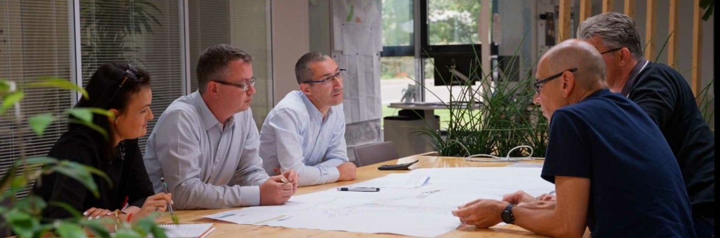 Vue de 5 membres du bureau d'études autour d'un plan