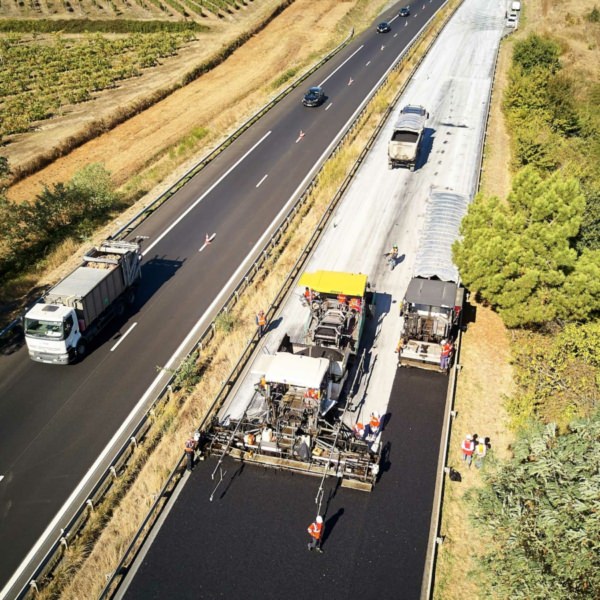 Vue aérienne d'un chantier d'autoroute : finisseur appliquant de l'enrobés recyclés