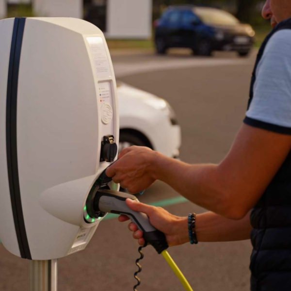 Homme qui débranche sa voiture éléctrique